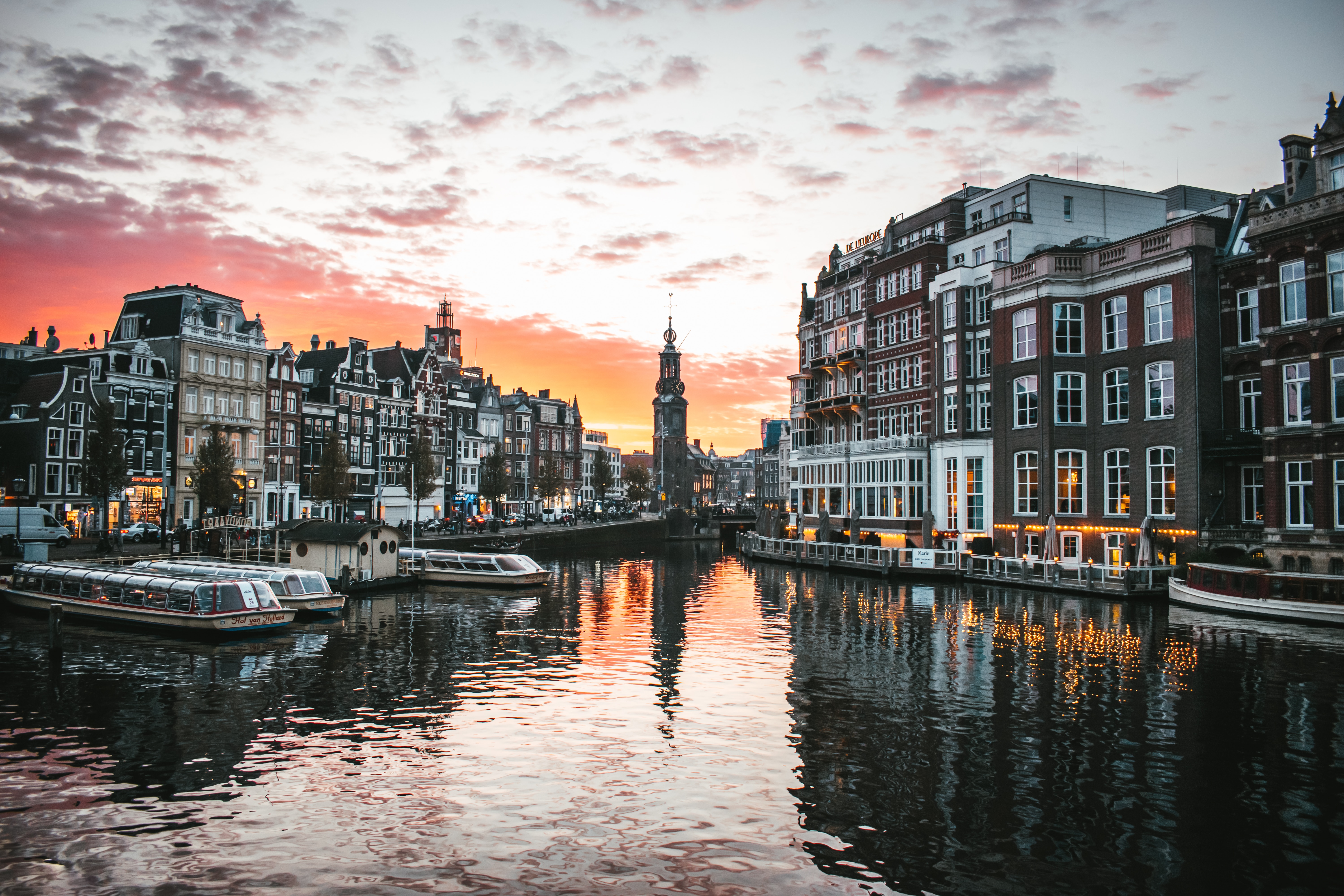 Amsterdamse gracht met boren, huizen en zonsondergang
